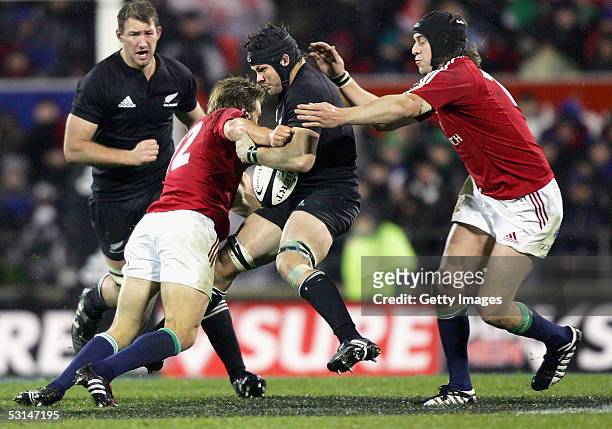 Jonny Wilkinson of the Lions puts a big tackle on Richie McCaw of the All Blacks as Ryan Jones assists during the match between the British and Irish...