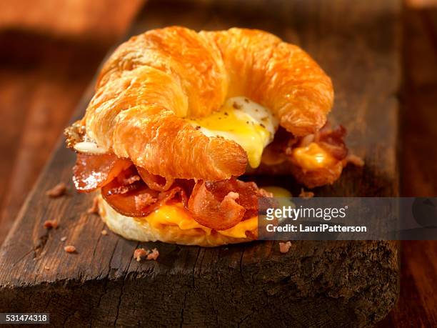 croissant-frühstück-sandwich mit speck, ei und käse - bacon and eggs stock-fotos und bilder