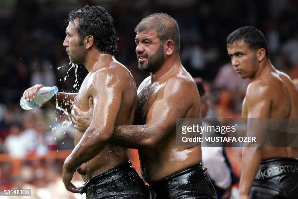 Turkish oilwrestler is massaged by another competitor while refreshing during the 644th historical Kirkpinar oilwrestling in Sarayici, near Edirne,...