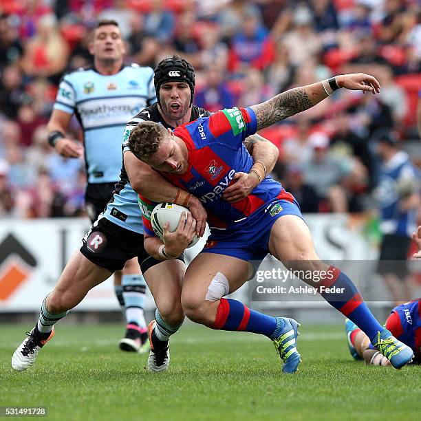 Michael Ennis of the Sharks tackles Korbin Sims of the Knights during the round 10 NRL match between the Newcastle Knights and the Cronulla Sharks at...