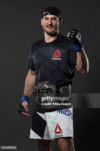 Stipe Miocic poses with his new UFC heavyweight championship belt backstage during the UFC 198 event at Arena da Baixada stadium on May 14, 2016 in...