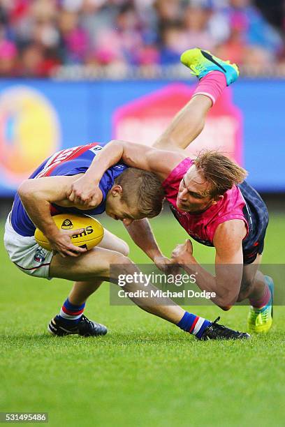 Bernie Vince of the Demons tackles Lachie Hunter of the Bulldogs during the round eight AFL match between the Melbourne Demons and the Western...