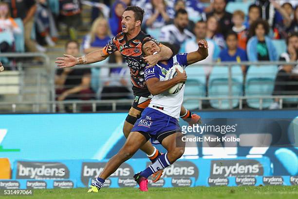 Justin Hunt of the Tigers tackles Moses Mbye of the Bulldogs high during the round 10 NRL match between the Wests Tigers and the Canterbury Bulldogs...