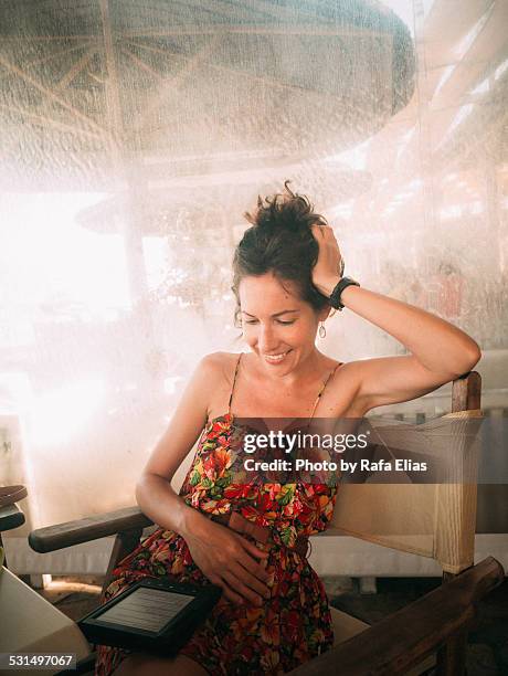 pretty woman reading e-reader - hand in den haaren stock-fotos und bilder