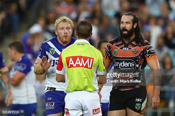 James Graham of the Bulldogs makes his point to the referee as Aaron Woods of the Tigers watches on during the round 10 NRL match between the Wests...