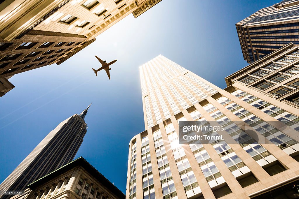 New York City, Manhattan Skyscraper With Airplane Against Sun