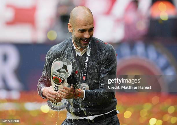 Josep Guardiola, coach of Bayern Muenchen is soaked by beer as he celebrates winning the Bundesliga after the Bundesliga match between FC Bayern...