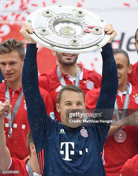 Goalkeeper Manuel Neuer of Muenchen lifts the Meisterschale as players and staffs celebrate the Bundesliga championship after the Bundesliga match...