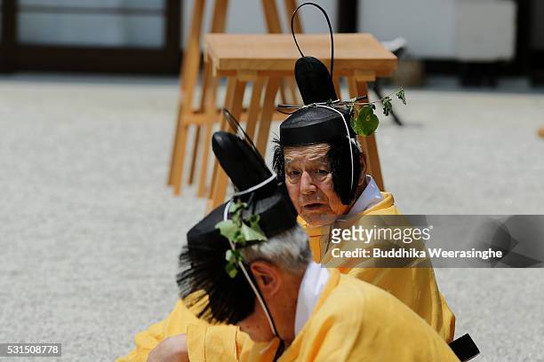 Two men dressed in Heian Period costumes as sit on the ground during the Aoi Festival at Shimogamo Shrine on May 15,2016 in Kyoto, Japan . Aoi...
