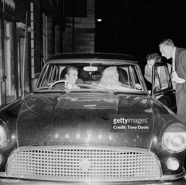 English actress Diana Dors and her husband English-American actor and comedian Richard Dawson talking to friends from their car, 1958.