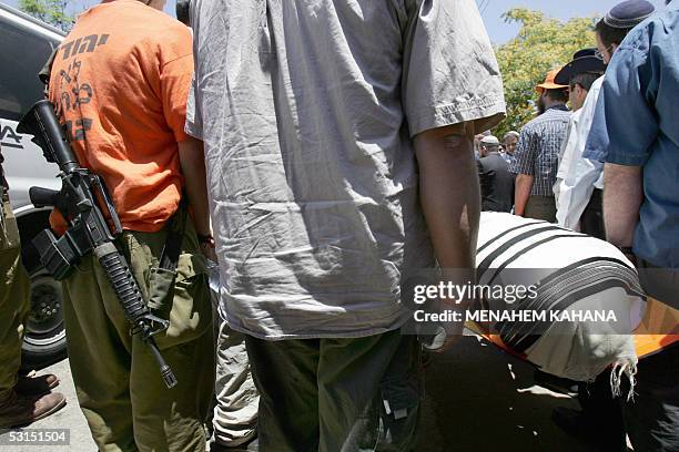 Israeli settlers carry the body of Avichai Levi during his funeral in the southern West Bank Settlement of Beit Hagay 26 June 2005. Avichai was...