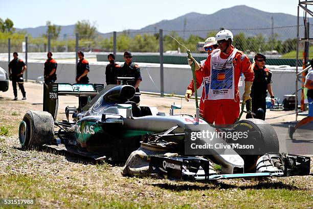 Marshals around the broken car of Lewis Hamilton of Great Britain and Mercedes GP after he crashed on the first lap during the Spanish Formula One...