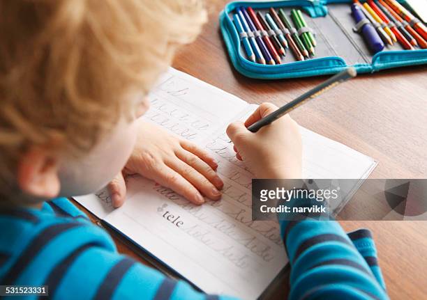 boy learning to write alphabet characters - workbook stock pictures, royalty-free photos & images
