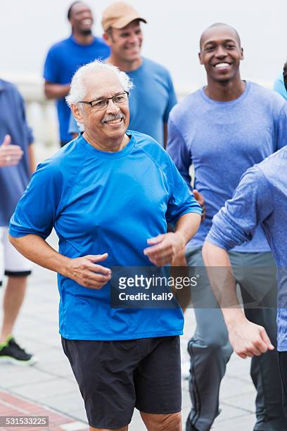 hispanic senior man running with group - people of different races stock pictures, royalty-free photos & images
