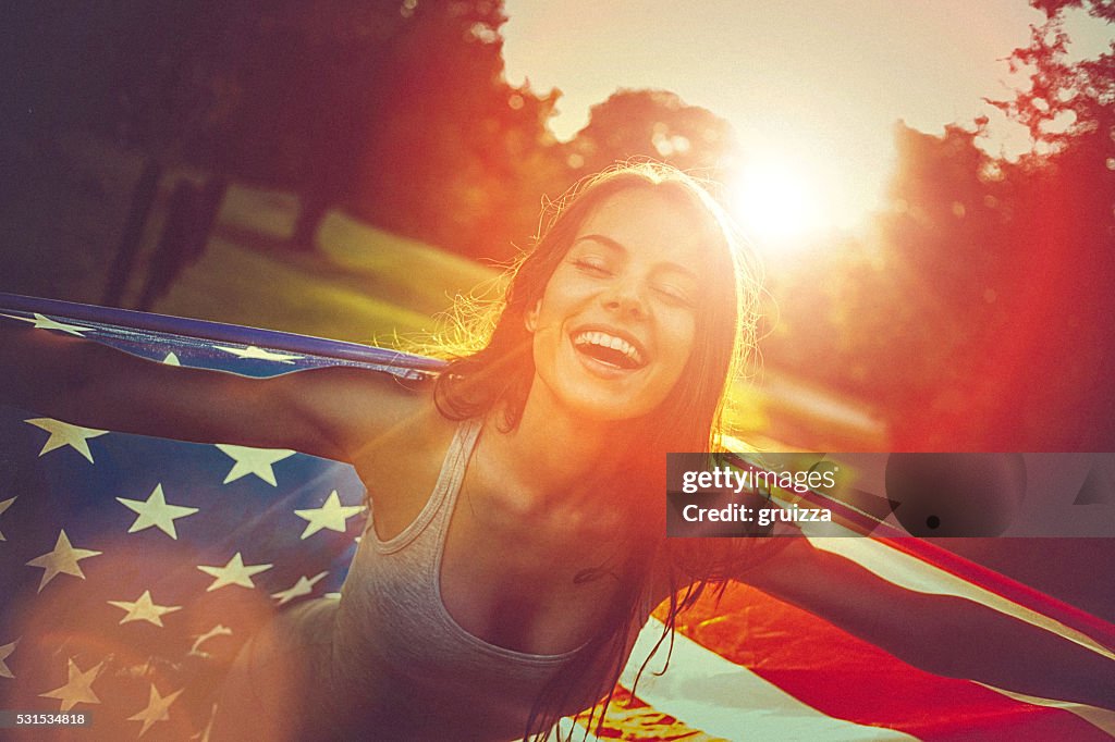 Junge Frau auf einer Wiese, die amerikanische Flagge