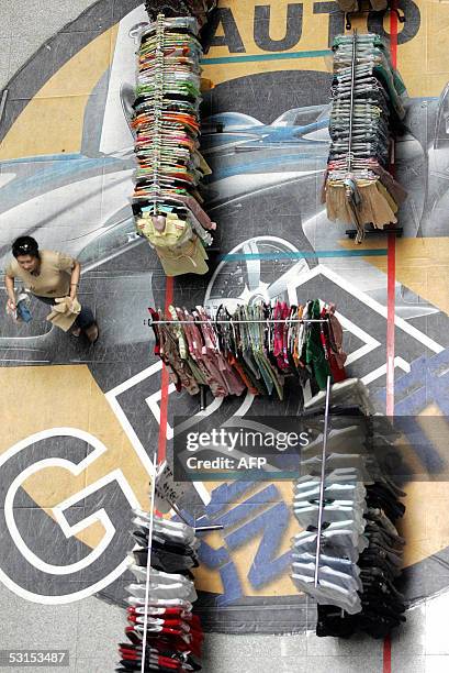 Shopper walks past various women fashion on display at the Golden Resources Shopping Mall in Beijing, 26 June 2005, which is four times bigger than...
