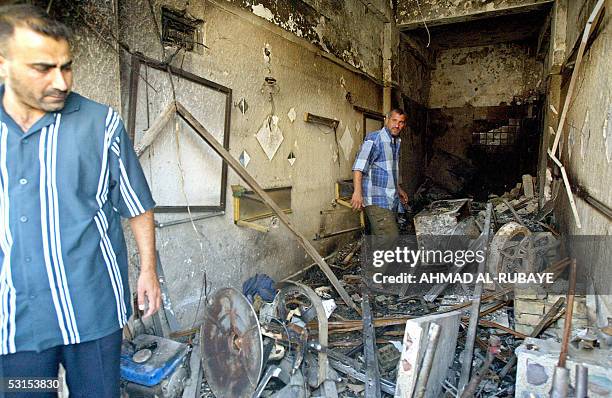 Iraqis inspect damage inside a barber shop in the bustling district of Baghdad Al-Jadida in the Iraqi war-torn capital, 27 June 2005. Three people...