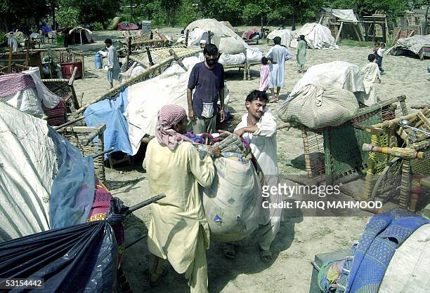 Afghan refugees salvage their belongings from their flood affected camp in the village of Khazana, some 20 kms from Peshawar, 27 June 2005. Following...