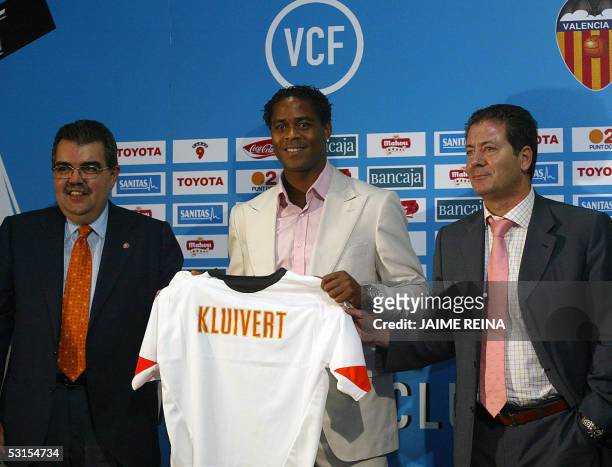 Dutch player Patrick Kluivert shows his Valencia T-shirt next to the club's president Juan Bautista Soler and Sport director Javier Subirats during...