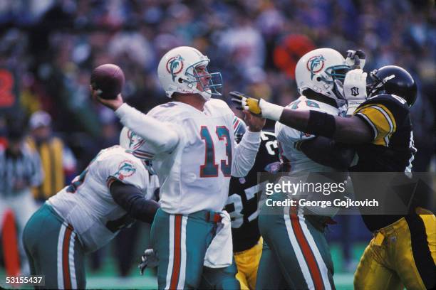 Quarterback Dan Marino of the Miami Dolphins passes as offensive lineman Richmond Webb blocks defensive lineman Kevin Henry of the Pittsburgh...