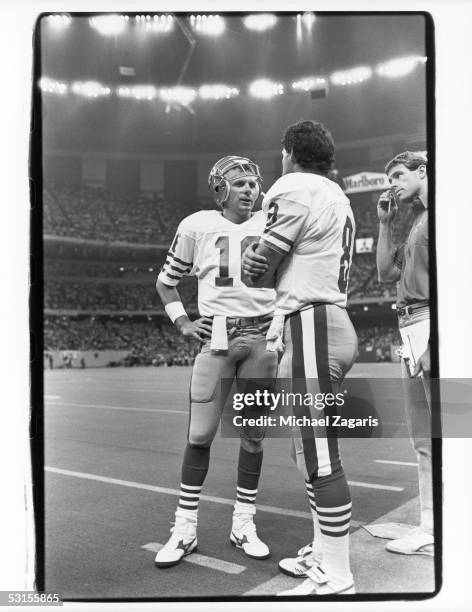 Joe Montana and Steve Young of the San Francisco 49ers discuss strategy during the game against the New Orleans Saints at the Louisiana Superdome on...