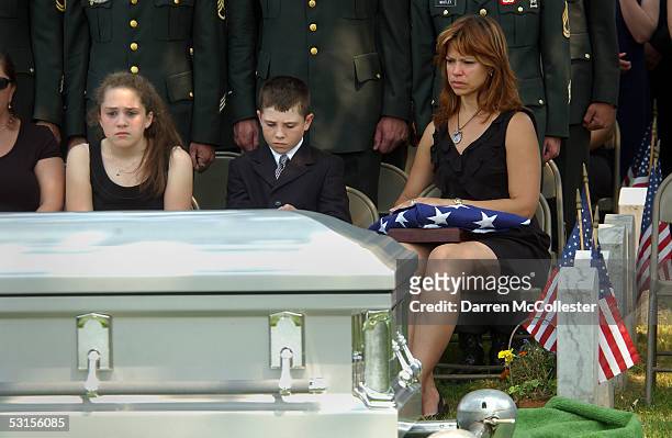 Connie Piper, son Christopher, and daughter Deidre sit beside the casket of their father/husband June 27, 2005 during his funeral in Marblehead,...