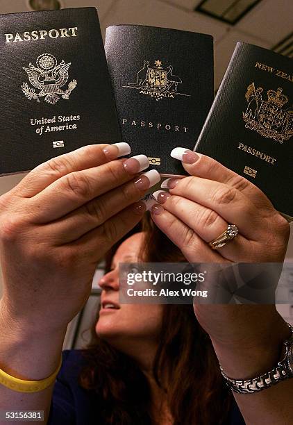 Kim Nivera, Chief of Business Management of US-VISIT entry-exit program, holds up sample copies of e-passports of the United States , Australia and...