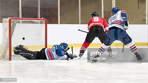 ice hockey players scoring goal - hockey player on ice stock pictures, royalty-free photos & images