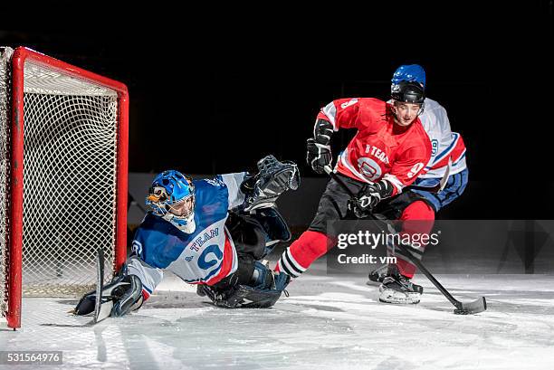 eishockey-spieler in aktion - ice hockey goaltender stock-fotos und bilder