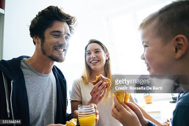 happy family having breakfast together - pain au chocolat stock pictures, royalty-free photos & images