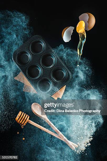 levitating kitchen utensils in a cloud of  (for honey muffins) - movimiento rápido fotografías e imágenes de stock