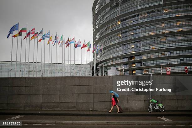 People make their way into the European Parliament during a rain storm on May 12, 2016 in Strasbourg, France. The United Kingdom will hold a...