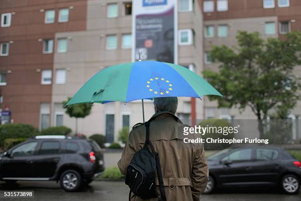 Man carrying an EU umbrella waits for a tram on May 12, 2016 in Strasbourg, France. The United Kingdom will hold a referendum on June 23, 2016 to...