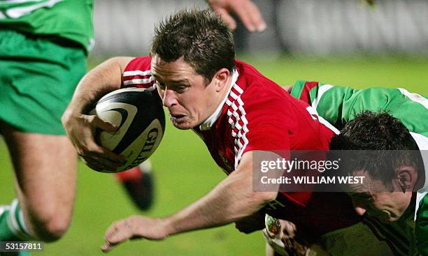 British and Irish Lions winger Shane Williams burst through the tackle of Manawatu's Hayden Triggs to score a try during their match in Palmerston...