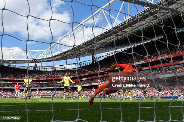 Mark Bunn of Aston Villa dives in vain as Olivier Giroud of Arsenal scores his team's first goal during the Barclays Premier League match between...