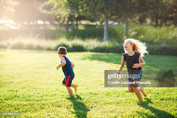 summer play - kids run free - running in park stockfoto's en -beelden