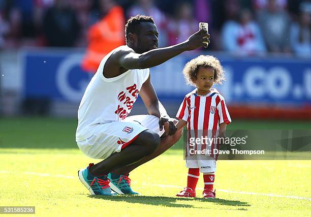 Mame Biram Diouf of Stoke City and his child are seen after the Barclays Premier League match between Stoke City and West Ham United at the Britannia...