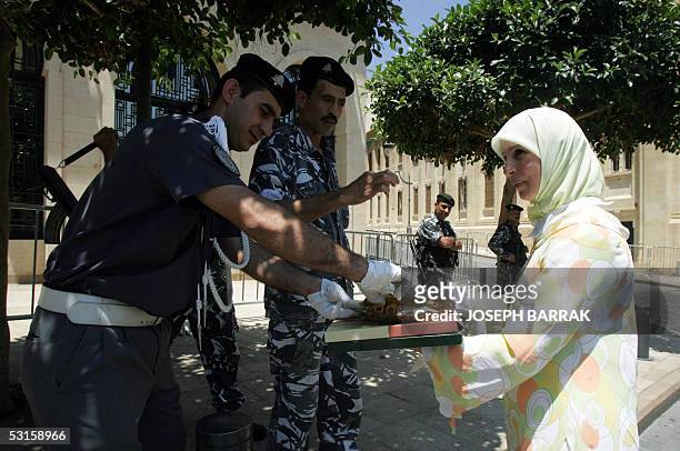 An employee at the Lebanese parliament in Islamic headscarf distributes sweets in front of the parliament building in Beirut after Speaker Nabih...
