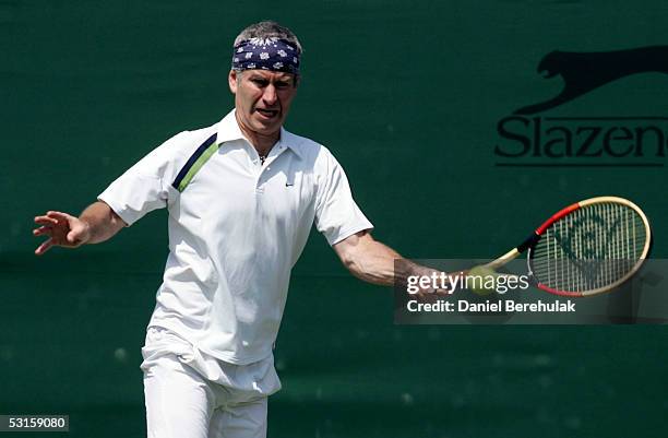 John McEnroe of USA in action with his partner Peter Fleming of USA during their over 45's doubles match against John Lloyd of Great Britain and John...