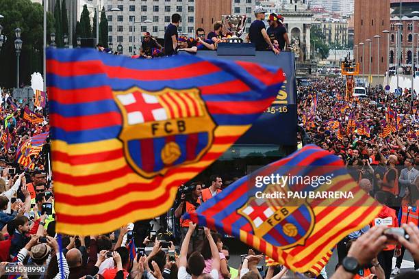 Supporters wave FC Barcelona flags as the team parades on a bus through the streets of Barcelona to celebrate their 24th La Liga title, in Barcelona,...