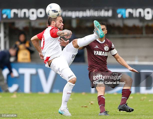 Federico Insua of Argentinos Juniors fights for the ball with Maximiliano Velazquez of Lanus during a match between Argentinos Juniors and Lanus as...