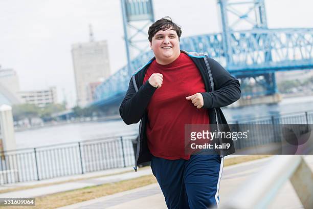 overweight young man running to lose weight - young man jogging stock pictures, royalty-free photos & images