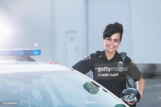 femme policier debout près de voiture de police - cop car photos et images de collection