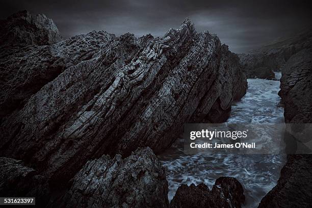 moody seascape with moving water - rock formation stock pictures, royalty-free photos & images