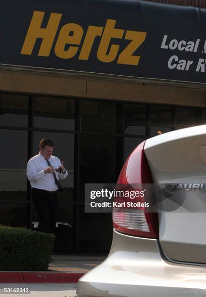 Man walks in front of a Hertz car rental store June 28, 2005 in Plano, Texas. Ford Motor Company recently announced plans to sell off the car rental...