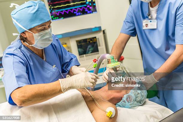 anesthetizing patient in operating theater - anesthetist stock pictures, royalty-free photos & images