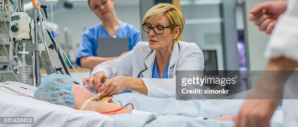 doctor checking patient - icu stockfoto's en -beelden