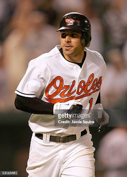 Brian Roberts of the Baltimore Orioles looks toward the Orioles dugout as he rounds the bases after hitting a solo home run in the bottom of the 10th...