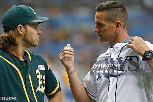 Josh Reddick of the Oakland Athletics speaks with former teammate Grant Balfour as Balfour dons a Tampa Bay Rays' jersey to throw out a ceremonial...