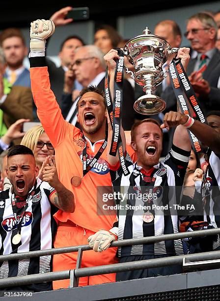 Craig Disley of Grimsby Town lifts the trophy with team mates during the Vanarama Football Conference League: Play Off Final match between Forest...